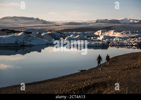 Touristes à la lagune de glacier de Jokulsarlon, un lac glaciaire rempli de icebergs dans le sud-est de l'Islande, en Europe Banque D'Images
