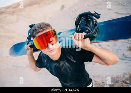 Snowboardeur homme surf sur les dunes à Dubaï, Émirats arabes Unis Banque D'Images