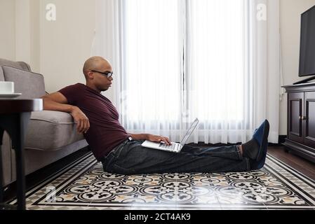 Homme lisant un document sur un ordinateur portable Banque D'Images