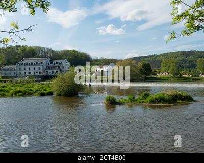 Vue sur la rivière Berounka dans le village de Zadni Treban avec le déversoir et la construction de l'hôtel Mlyn Karlstejn, jour d'été ensoleillé, République tchèque Banque D'Images
