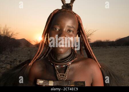 Une jeune femme Himba au coucher du soleil en Namibie. Banque D'Images