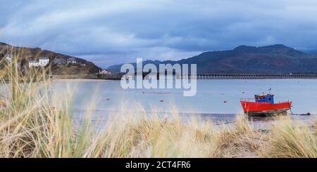 Vieux bateau de pêche et pont de Barmouth dans le port de Barmouth avec les montagnes de Cader (Cadair) derrière (partie du parc national de Snowdonia), Gwynedd, le nord du pays de Galles, le pays de Galles, le Royaume-Uni, l'Europe Banque D'Images