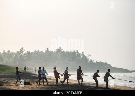 Pêcheurs tirant dans de grands filets de pêche sur la plage tropicale de Kappil, Varkala, Kerala, Inde Banque D'Images