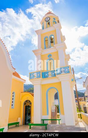 Église orthodoxe traditionnelle jaune avec dôme en brique rouge dans le village de Diafani, île de Karpathos, Grèce Banque D'Images