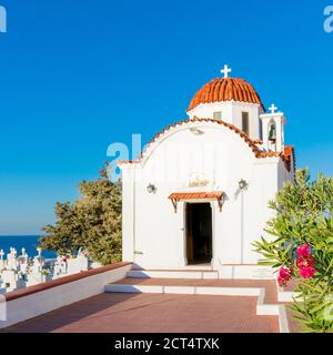 Église traditionnelle sur l'île de Karpathos avec dôme rouge, vue sur la mer et cimetière, Grèce Banque D'Images