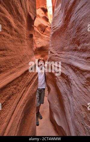 Randonneur à Spooky Gulch, un canyon à créneaux, secteur du banc de Weed tôt, BLM Land, anciennement partie du monument national Grand Staircase Escalante, Utah, États-Unis Banque D'Images