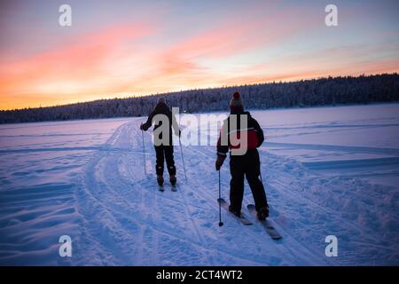 Ski sur le lac gelé à Torassieppi au coucher du soleil, Laponie, Finlande Banque D'Images