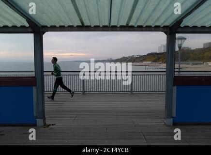 Jogger longe la jetée de Bournemouth après le coucher du soleil. 24 avril 2013. Photo: Neil Turner Banque D'Images