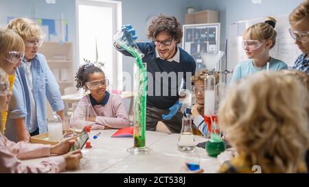 École élémentaire de chimie scientifique classe : le professeur montre l'expérience de réaction chimique à un groupe d'enfants. Mélange de produits chimiques dans le bol pour obtenir Banque D'Images