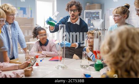 École élémentaire de chimie scientifique classe : le professeur montre l'expérience de réaction chimique à un groupe d'enfants. Mélange de produits chimiques dans le bol pour obtenir Banque D'Images