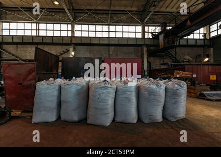 Sacs en polyéthylène blanc avec produits d'usine en entrepôt Banque D'Images
