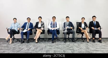 les hommes d'affaires asiatiques attendent en file d'attente pour un entretien d'embauche à l'appareil photo Banque D'Images
