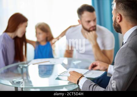 un couple de familles caucasiennes s'est tourné vers un avocat pour signer un accord de divorce, l'homme et la femme se querellent toujours et se disputent les uns avec les autres Banque D'Images