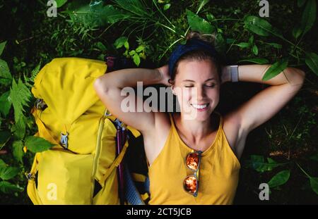 Vue de dessus de la femme randonneur couché sur le sol à l'extérieur en forêt, au repos. Banque D'Images