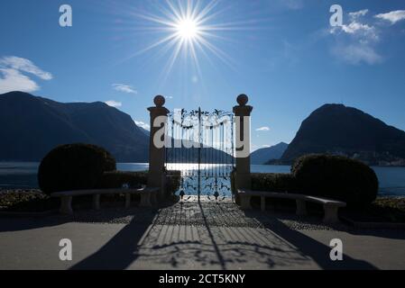 Porte sur un lac alpin de Lugano avec Sunbeam et la montagne au Tessin, Suisse. Banque D'Images