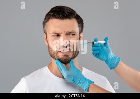 Homme barbu qui obtient une injection de beauté en salon Banque D'Images