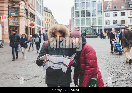 Wurzburg/Germany-3/1/19: Un jeune couple vérifie la carte tout en marchant dans le centre-ville de Wurzburg par une froide journée d'hiver. La ville est célèbre pour son ri Banque D'Images