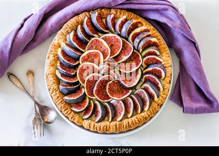 Une femme qui a mis en place une tarte aux figues colorée avec du glaçage sucre sur la table de cuisine Banque D'Images