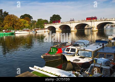 Des bateaux amarrés le long de la Tamise tandis que deux bus rouges traversent le pont de Kingston à Kingston upon Thames, dans le Grand Londres, au Royaume-Uni Banque D'Images