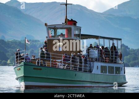 Les passagers portent des masques lorsqu'ils voyagent à bord du MV Western Belle, un steamer d'Ullswater qui s'approche du pont Pooley sur Ullswater, qui est le deuxième plus grand lac du Lake District de Cumbria. Mardi est le premier jour de l'automne astronomique. Banque D'Images
