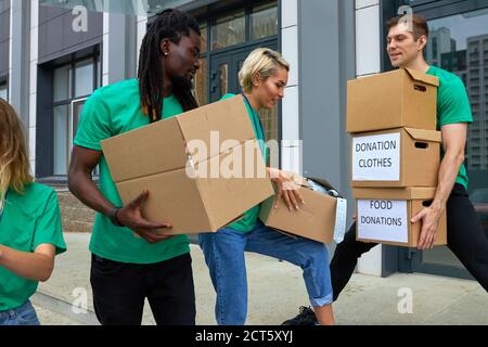 divers volontaires emballant, collectant l'aide humanitaire dans une boîte de dons. groupe multiethnique de personnes travaillant dans des fondations caritatives aidant dans les cris Banque D'Images