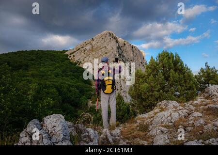 Homme puissant randonneur prenant des photos avec un smartphone au sommet de la montagne. Une merveilleuse pause. Le concept d'activité et la disponibilité de la connexion mobile Banque D'Images