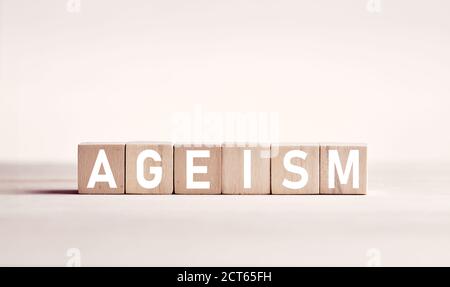 Le mot ageisme sur des blocs de bois sur fond blanc. La discrimination fondée sur l'âge dans le concept d'entreprise. Banque D'Images