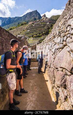 Les touristes à explorer les ruines Inca de Machu Picchu, région de Cuzco, Pérou, Amérique du Sud Banque D'Images