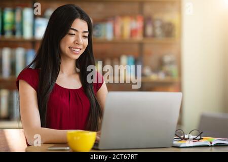 Sites Web de recherche d'emploi. Jeune femme asiatique utilisant un ordinateur portable au café, vérifier les postes vacants Banque D'Images