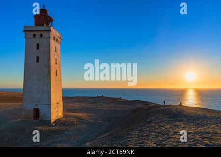 Phare de Rubjerg Knude, Danemark, au coucher du soleil. Les gens qui regardent les dunes. Banque D'Images