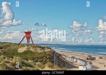 La plage de Blokhus sur la côte danoise de la mer du Nord avec ses cabanes de plage et son phare sur la dune Banque D'Images