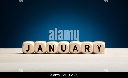 Le mois de janvier écrit sur des cubes en bois avec fond bleu d'hiver avec espace de copie. Mois de l'année. Banque D'Images