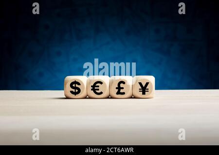 Symboles de devises ou panneaux sur des cubes en bois avec fond de facture. Dollar, euro, livre sterling et yuan ou yen. Banque D'Images