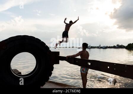 28 août 2019: Groupe de jeunes garçons jouant dans le port de Cienfuegos. Cienfuegos, Cuba Banque D'Images