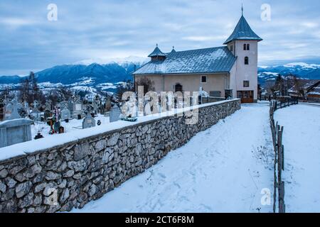 Église dans les montagnes enneigées des Carpathes en hiver, Bran, Transylvanie, Roumanie Banque D'Images