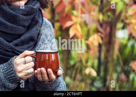 Tasse de café ou de thé dans les mains des femmes dans le parc d'automne. Automne (automne) ambiance, confortable, amour et romance concept. Copier l'espace Banque D'Images