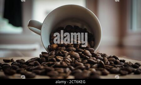 29/5000 grains de café déversés de la tasse Banque D'Images