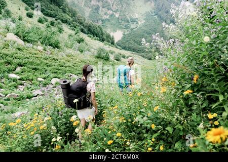 Une vue arrière des randonneurs avec des sacs à dos en cours d'expédition en montagne. Banque D'Images