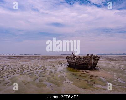 Ancienne barge en bois échouée à marée basse à Naklua, province de Chonburi, Thaïlande. Banque D'Images