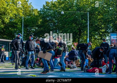 Amsterdam, pays-Bas. 21 septembre 2020. Des policiers arrêtent des militants de la XR (rébellion d'extinction) pendant la manifestation.pour la deuxième fois et dans le cadre de la nouvelle campagne sur le climat, des milliers d'activistes de la rébellion d'extinction ont bloqué la route principale du quartier financier lors d'un acte de désobéissance civile pacifique. Grâce à ces actions, XR exige une Assemblée des citoyens pour une politique climatique équitable. Après quelques heures, plusieurs d'entre eux ont été arrêtés par la police néerlandaise. Crédit : SOPA Images Limited/Alamy Live News Banque D'Images