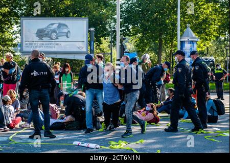 Amsterdam, pays-Bas. 21 septembre 2020. Les policiers arrêtent un militant de la XR (rébellion des extinction) pendant la manifestation. Pour la deuxième fois et dans le cadre de la nouvelle campagne sur le climat, des milliers de militants de la rébellion des extinction ont bloqué la route principale du quartier financier lors d'un acte de désobéissance civile pacifique. Grâce à ces actions, XR exige une Assemblée des citoyens pour une politique climatique équitable. Après quelques heures, plusieurs d'entre eux ont été arrêtés par la police néerlandaise. Crédit : SOPA Images Limited/Alamy Live News Banque D'Images