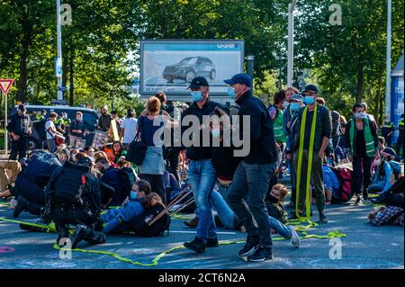 Amsterdam, pays-Bas. 21 septembre 2020. Les policiers arrêtent un militant de la XR (rébellion des extinction) pendant la manifestation. Pour la deuxième fois et dans le cadre de la nouvelle campagne sur le climat, des milliers de militants de la rébellion des extinction ont bloqué la route principale du quartier financier lors d'un acte de désobéissance civile pacifique. Grâce à ces actions, XR exige une Assemblée des citoyens pour une politique climatique équitable. Après quelques heures, plusieurs d'entre eux ont été arrêtés par la police néerlandaise. Crédit : SOPA Images Limited/Alamy Live News Banque D'Images