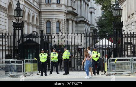 Jeune couple vu regardant dans Downing Street, gardée par la police, étant les seuls touristes que le moment pendant la pandémie du coronavirus ( Covid-19 ). Banque D'Images