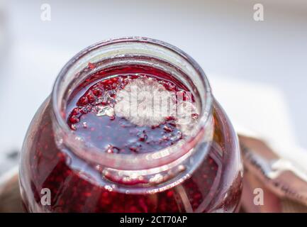 Moulez dans un pot de confiture de framboises. Dangereux pour la santé. Banque D'Images