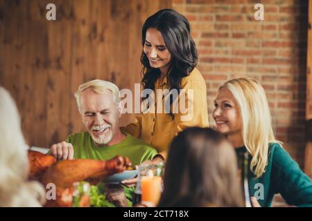 Réunion de famille la jeune génération prenant soin de la vieille génération célébrer thanksgiving manger table maison salle de séjour à l'intérieur Banque D'Images