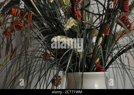Arrangement de fleurs. Arrangement de fleurs multicolores et non naturelles dans un vase en céramique, avec une mise au point sélective et un arrière-plan flou Banque D'Images