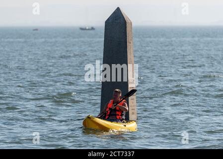 Southend on Sea, Essex, Royaume-Uni. 21 septembre 2020. Le temps a fait sombre et nuageux à Southend sur la mer, mais a éclaté dans un après-midi chaud et ensoleillé. Les gens sont dehors en appréciant la marée haute de l'après-midi avec un peu de prendre à l'eau. Un canoéiste mâle passant devant la Crow Stone au large de la plage de Chalkwell Banque D'Images