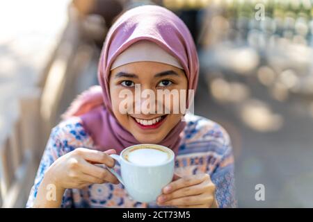 Bonne jeune femme musulmane boire du café Banque D'Images