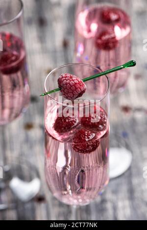 Cocktail rose pétillant avec une framboise. Banque D'Images