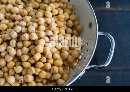Pois chiches trempés égouttés dans une passoire : haricots garbanzo séchés qui ont été trempés dans de l'eau et égouttés dans une passoire Banque D'Images
